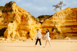 a couple in love walking on sao rafael beach in albufeira