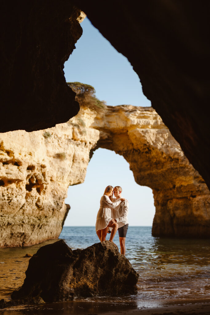 couple kissing by albandeira arch portugal