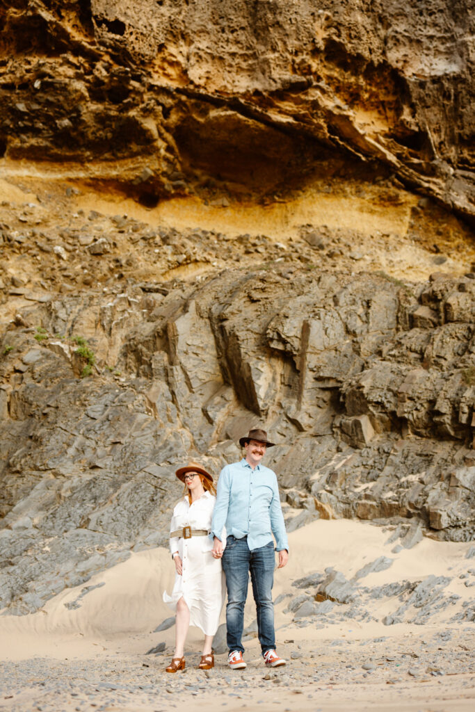 Couple standing in front of rocky cliff