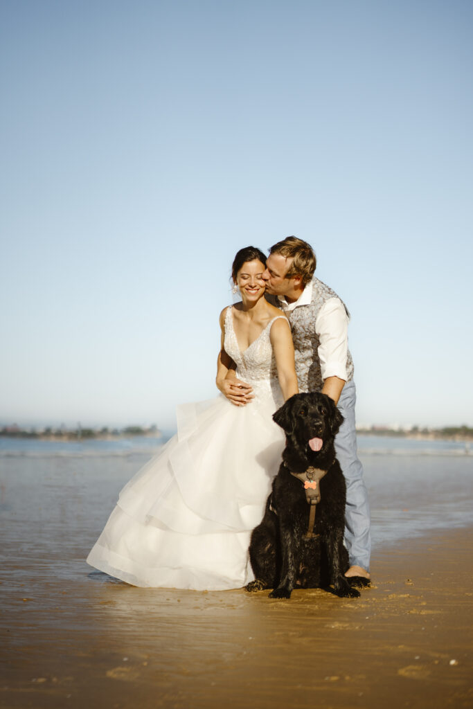 Bride and groom on the beach with dog
