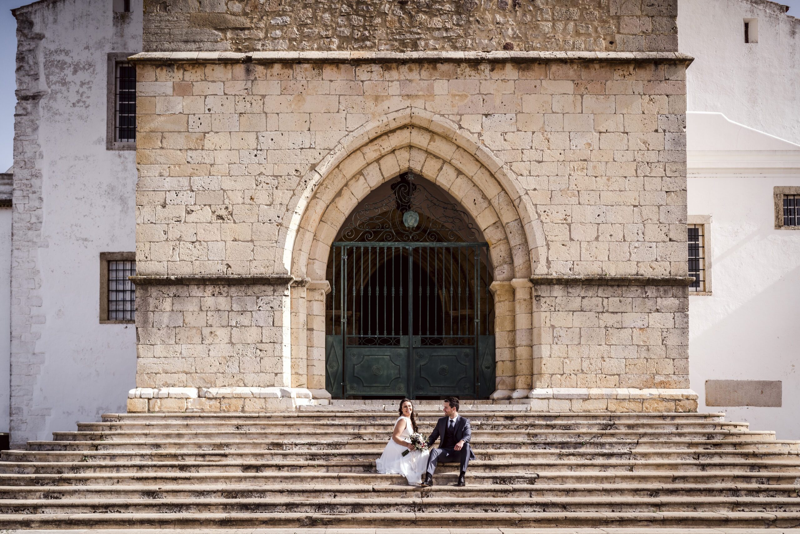 Happy newlyweds in old town of Faro, Portugal.