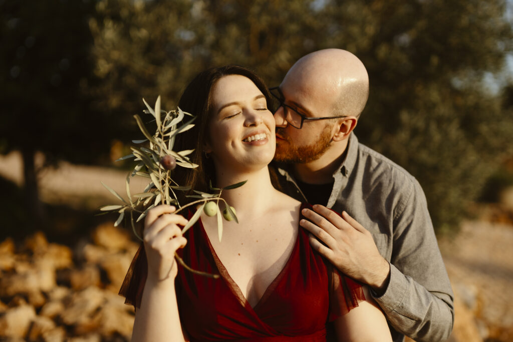 Engagement photo of man kissing fiancé on the cheek