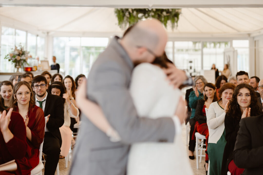 bride and groom hugging during the wedding day with focus on the guests