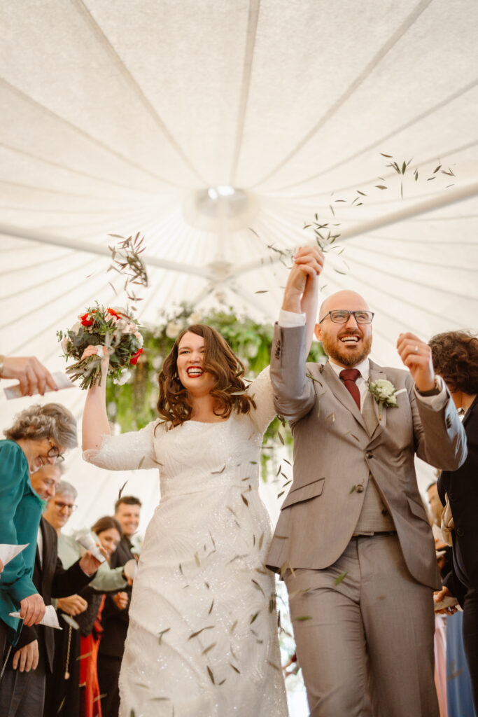 Bride and groom happily walk down the aisle together