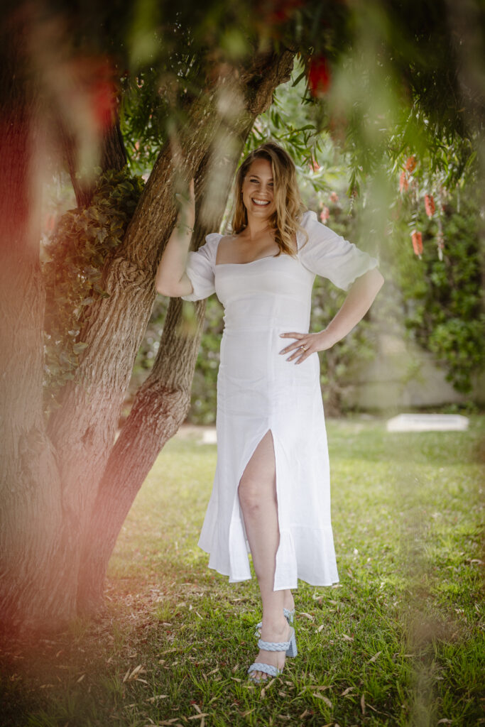 Bride poses next to tree in Alvor, Portugal