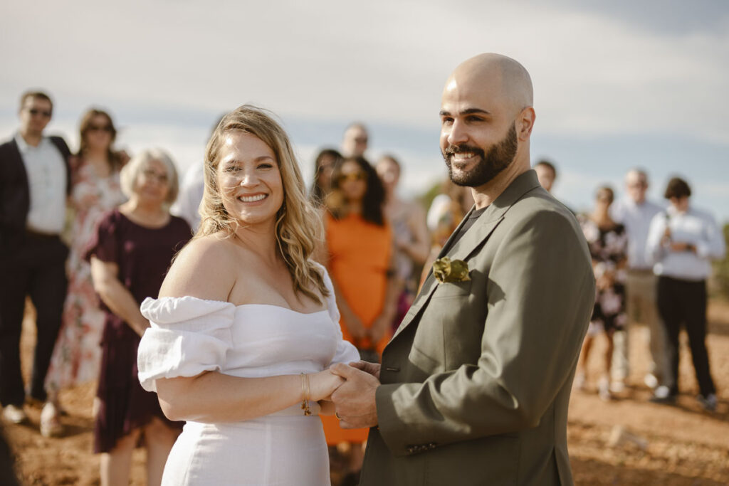 Bride and groom hold hands at alter in Alvor, Portugal