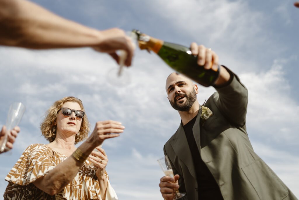 Photo of groom pouring champagne