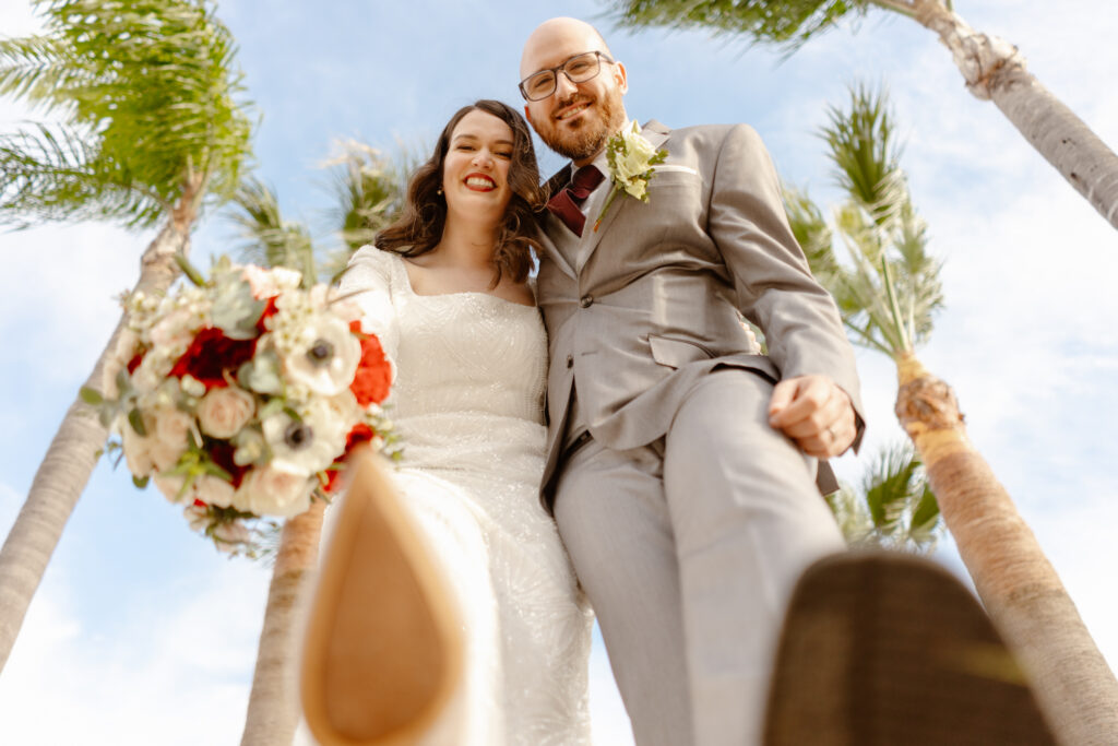 Portrait of happy bride and groom and palms in the background
