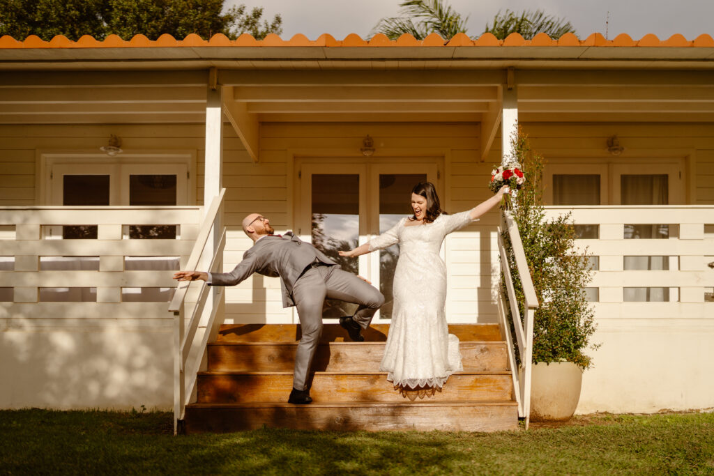 Groom falls backwards as bride raises bouquet in the air