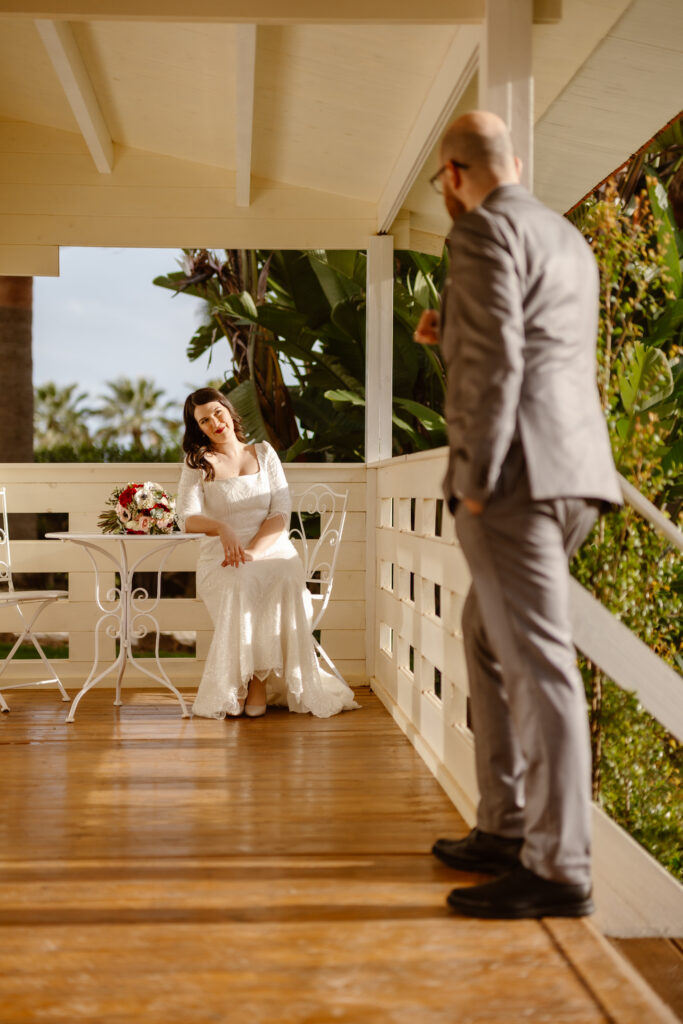 Bride and groom stare lovingly at one another on porch