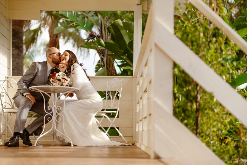 Portrait of happy bride and groom kissing on the patio