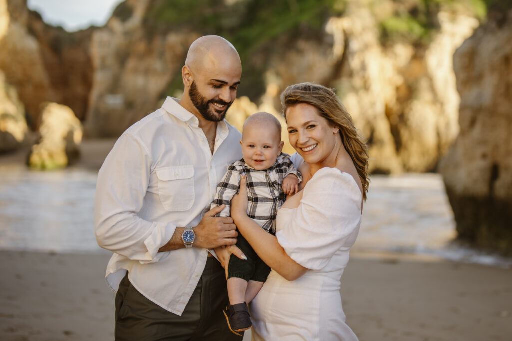 Bride and groom with their baby on the beach