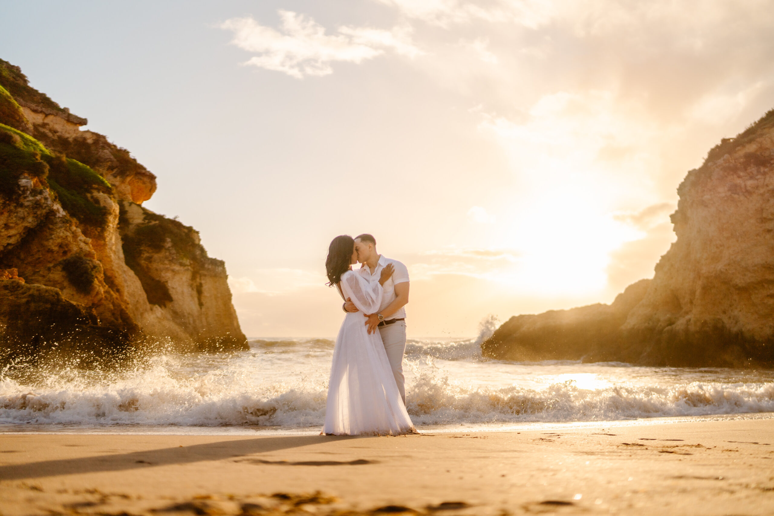 A couple kissing in front of small waves