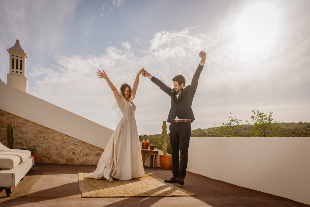 Bride and groom hands in air in Loule, Portugal