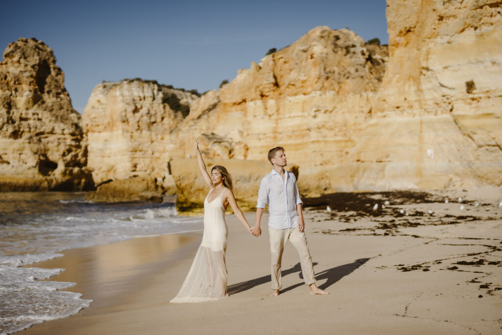 Couple hold hands at the beach