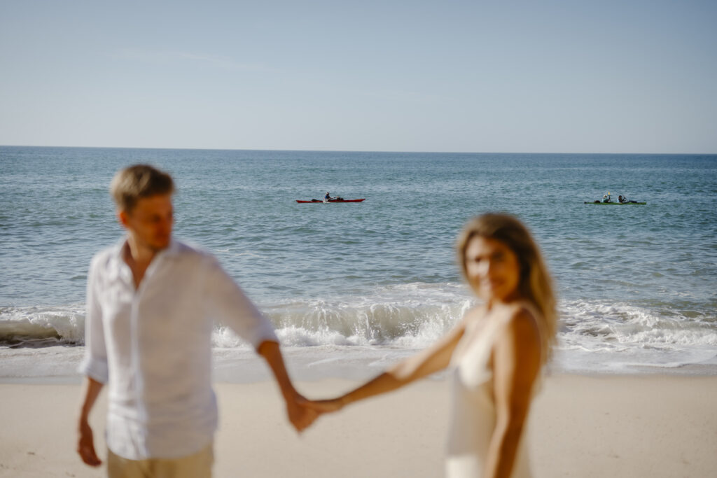 Couple hold hands at beach