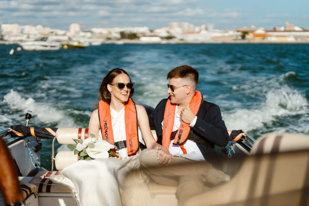 Bride and groom in life jackets on the speedboat in Algarve.
