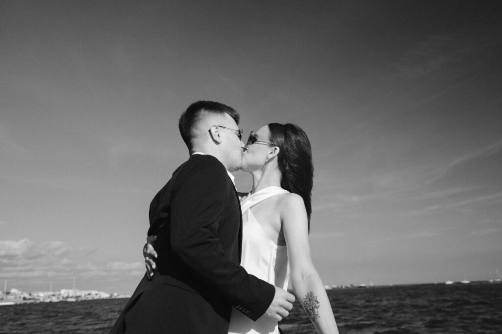 Bride and groom kiss on boat in Algarve, Portugal