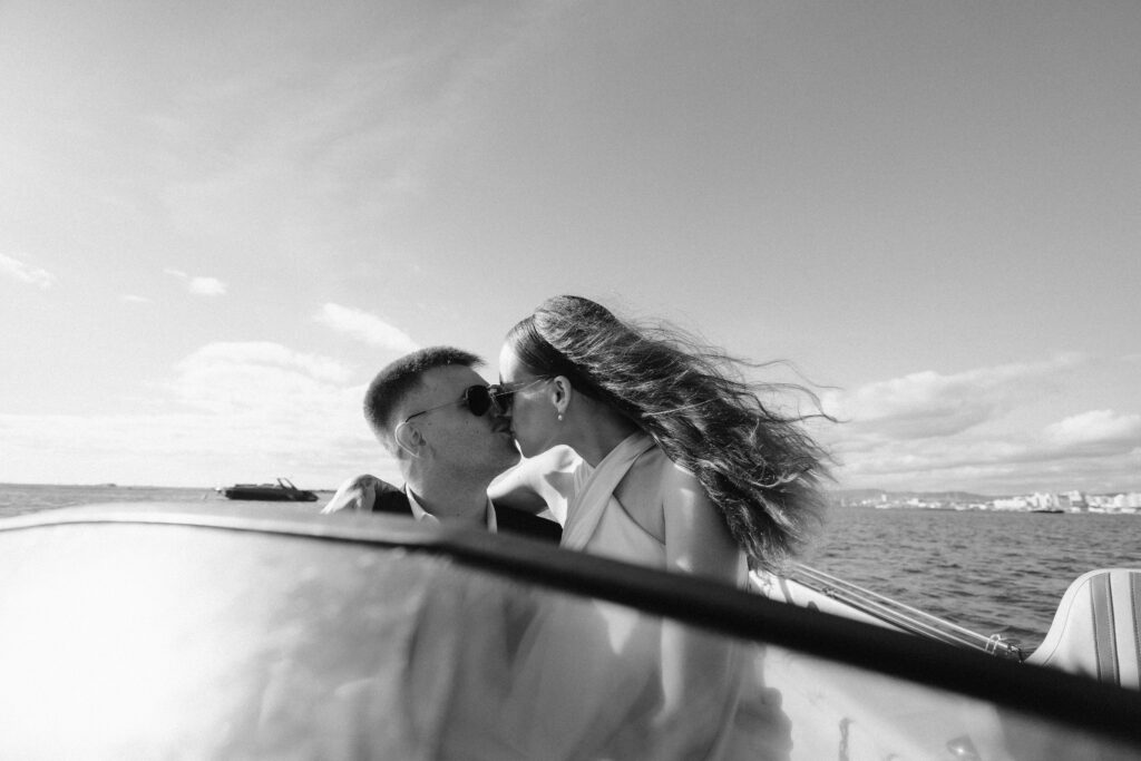 Bride and groom kiss on boat in Algarve, Portugal