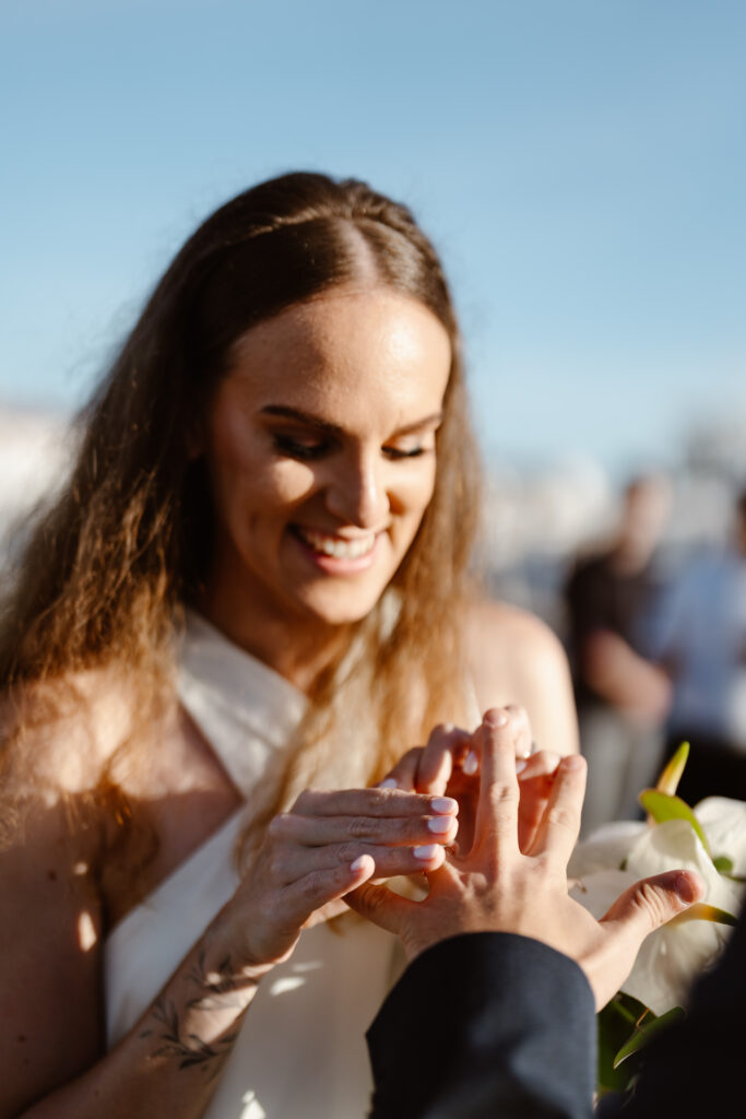 Bride places ring on grooms finger in Algarve, Portugal
