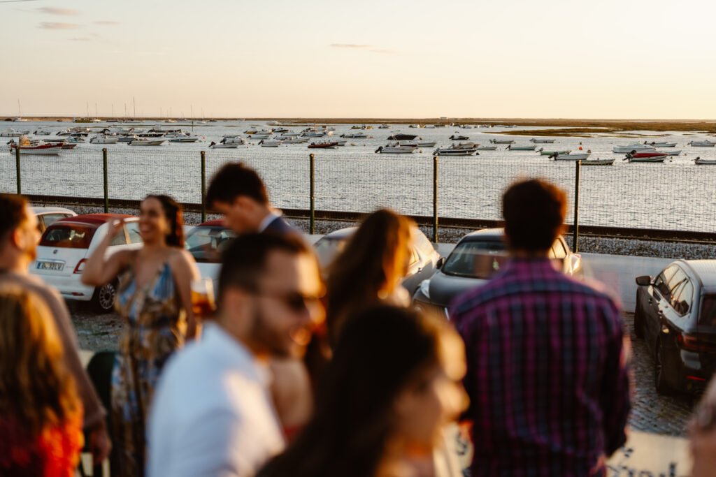 Wedding guests stand in front of boat area in Algarve, Portugal
