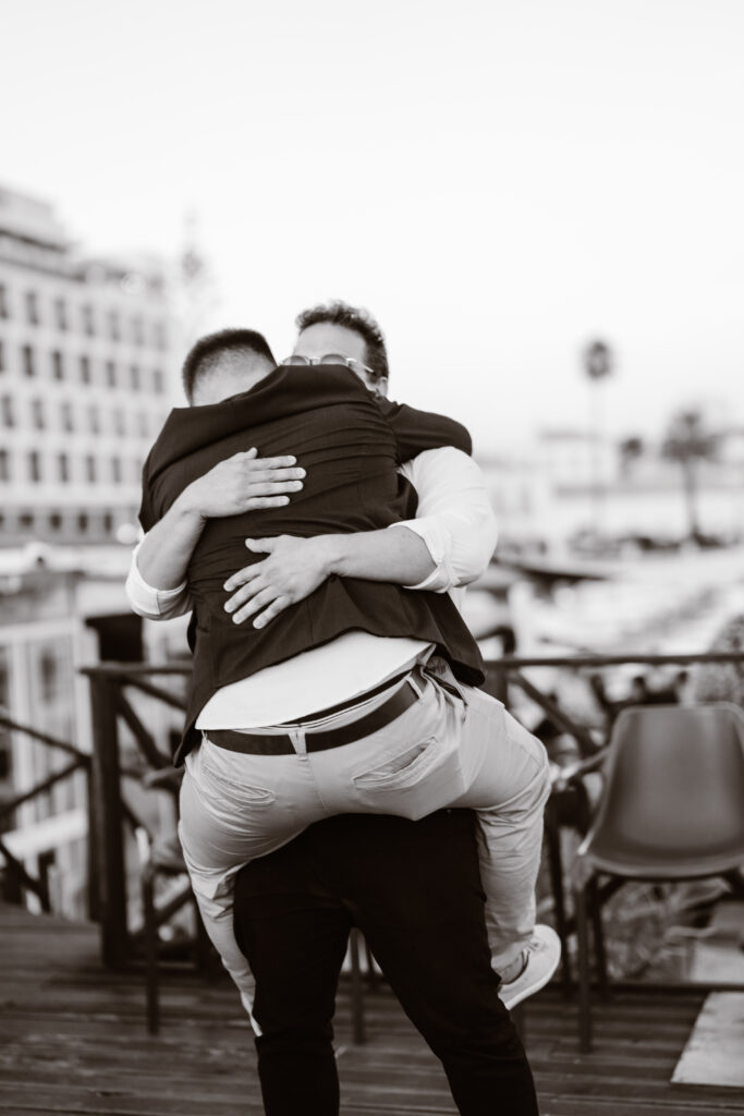 Groom and best man hug in Algarve, Portugal