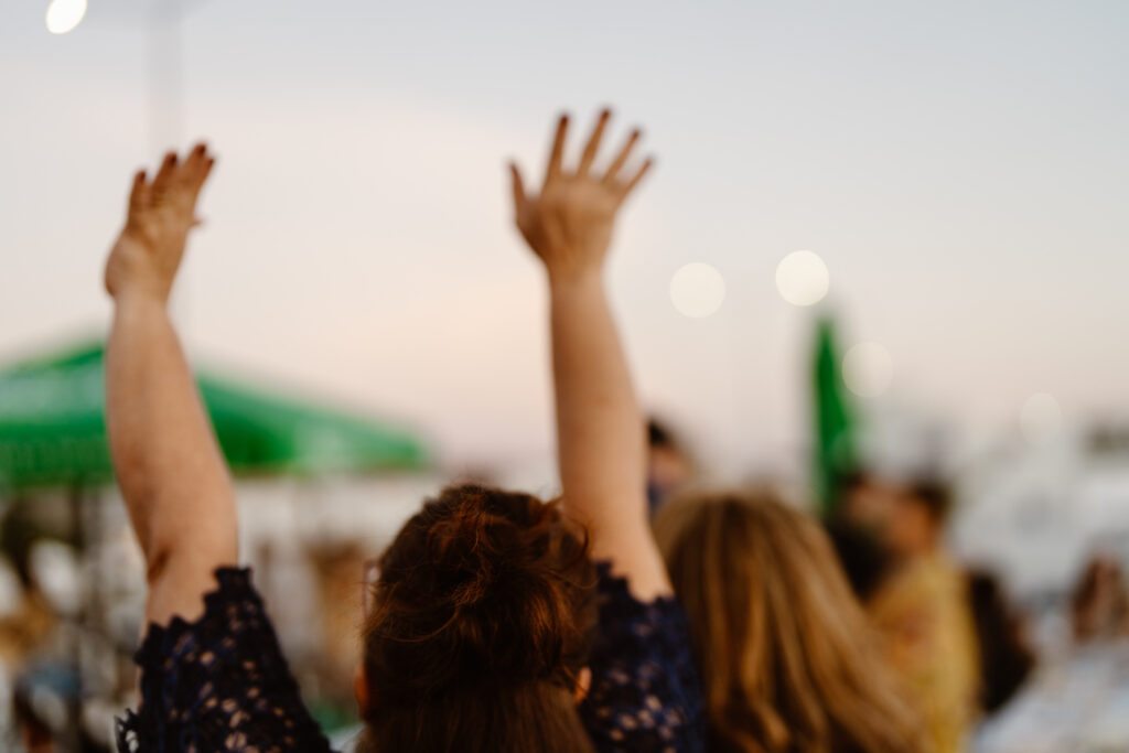 Woman raises her arms in the air in Algarve, Portugal