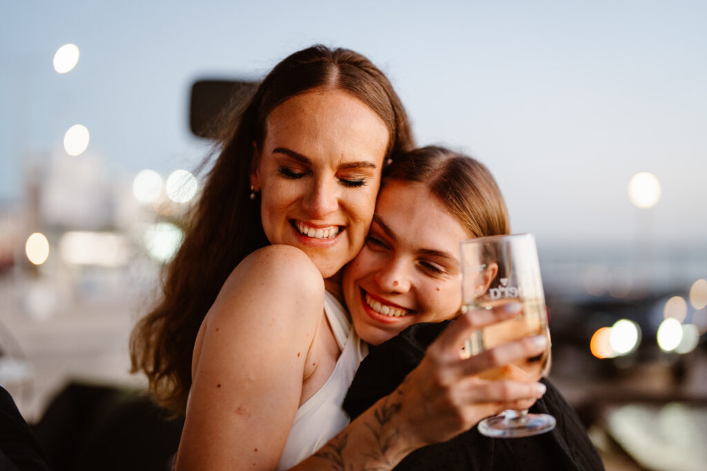 Smiling girl hugs the happy bride. Elopement in Portugal.