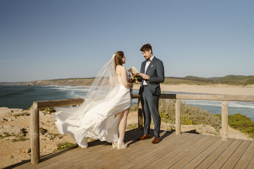 Groom reads vows to bride in Bordeira, Portugal