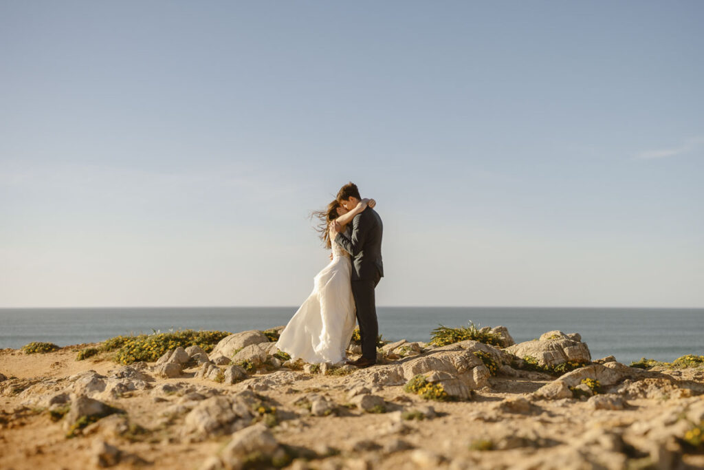 Bride and groom kissing in Bordeira, Portugal