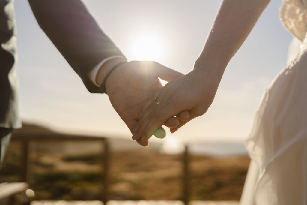 Bride and groom holding hands in Bordeira, Portugal