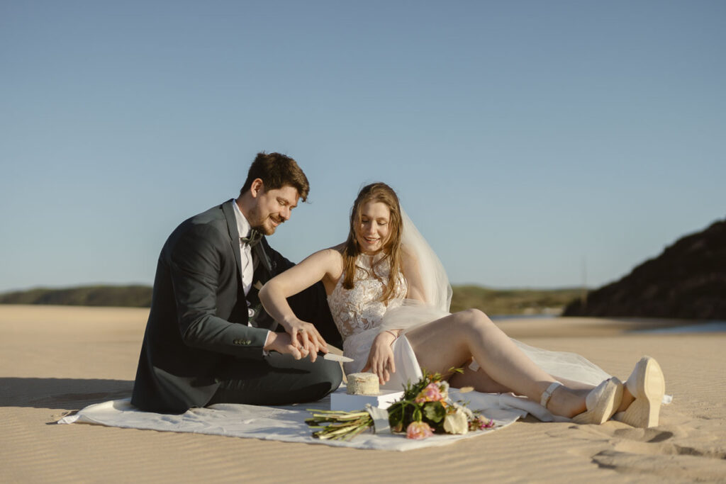 Bride and groom cut cake in Bordeira, Portugal