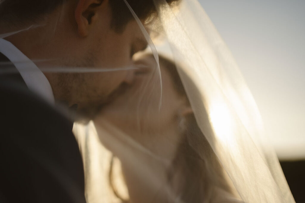 Bride and groom kiss in Bordeira, Portugal