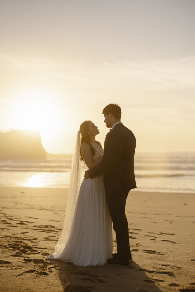 Bride and groom on beach in Bordeira, Portugal