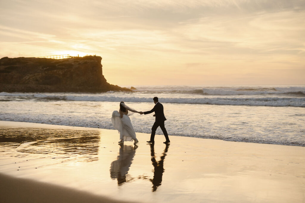 Bride and groom walking on beach in Bordeira,elopement in Portugal