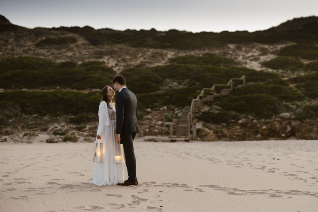 Bride and groom on beach in Bordeira, Portugal