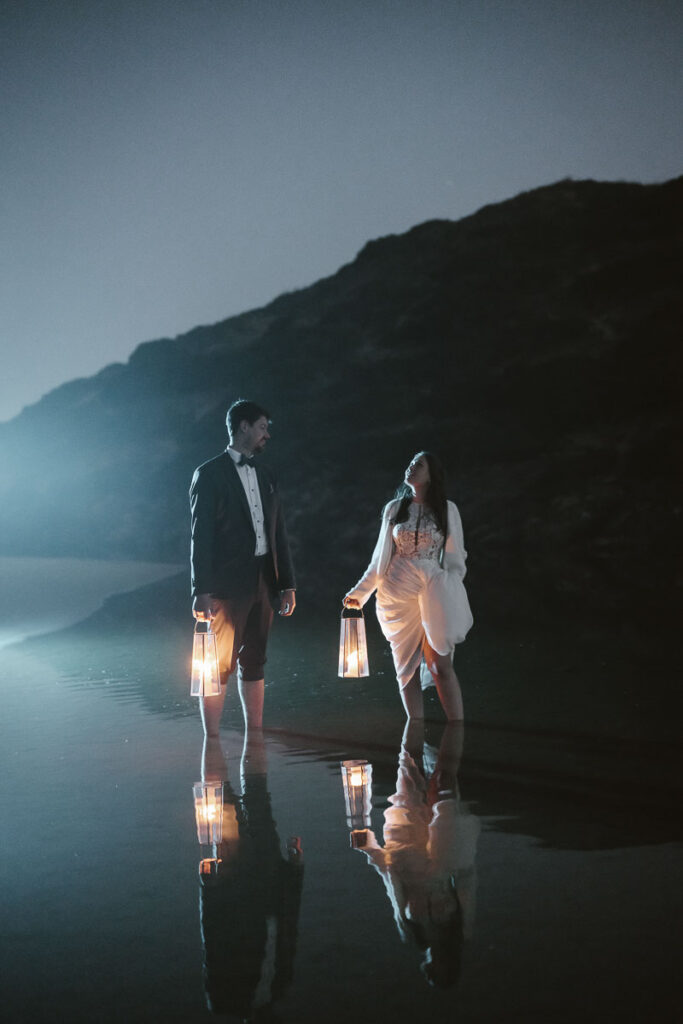 Bride and groom in water in Bordeira, Portugal