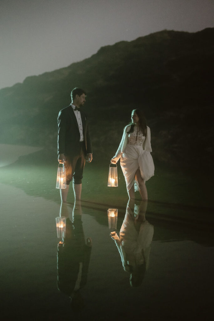 Bride and groom in water in Bordeira, Portugal