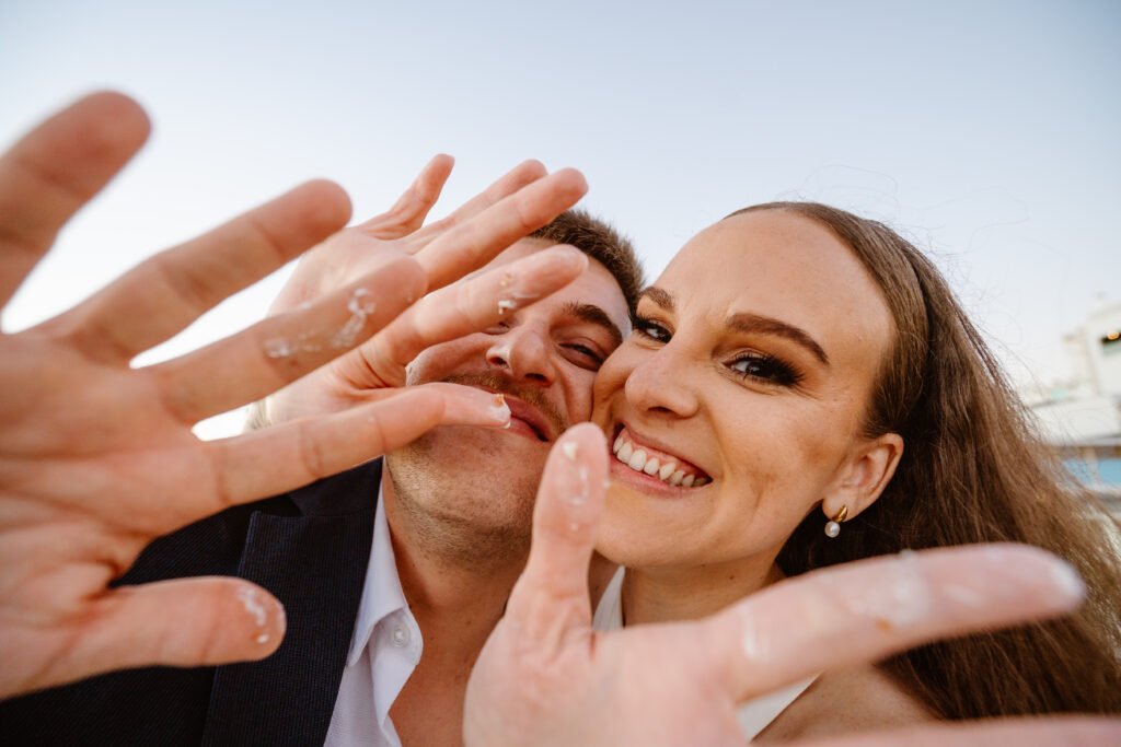 Sweet hands of bride and groom after eating wedding cake. Elopement in Algarve
