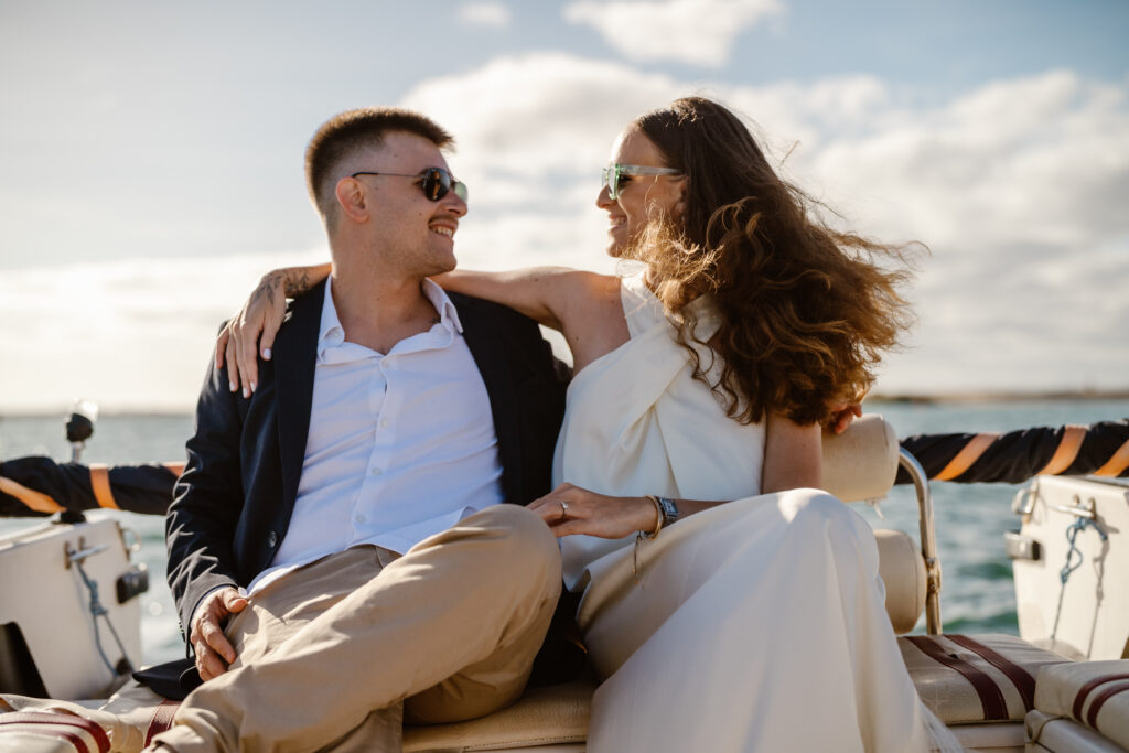 Happy bride and groom on the boat during wedding photo shoot.