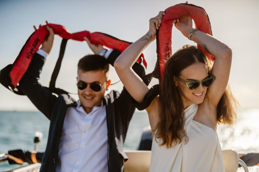 Bride and groom remove life jackets in Algarve, Portugal