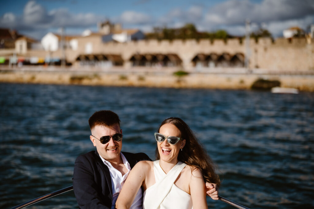 Bride and groom laugh together on boat in Algarve, Portugal