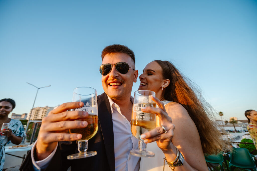 Bride and groom hold drinks together in Algarve, Portugal