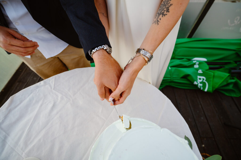Cutting the wedding cake together by bride and groom.