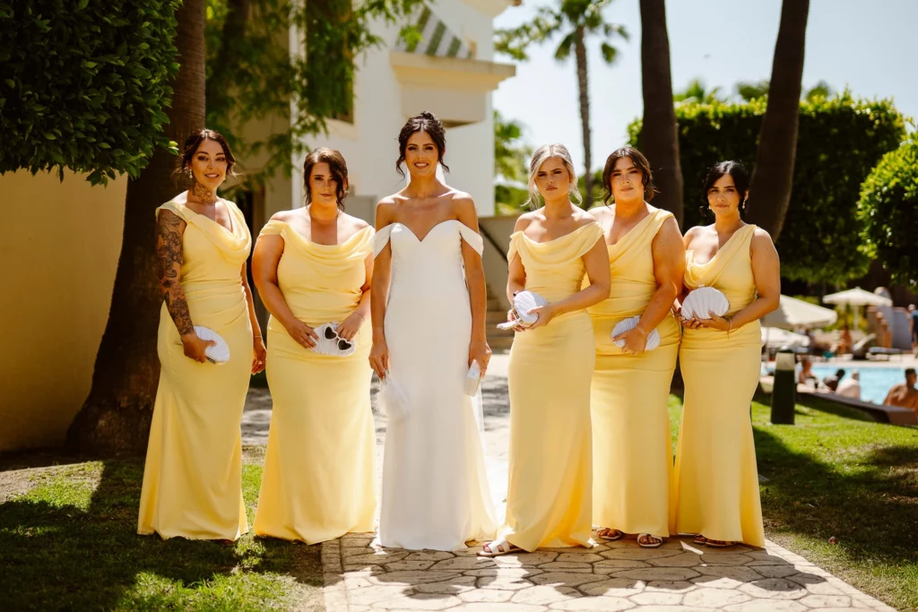 Bride and bridesmaids walking under palm trees in Algarve