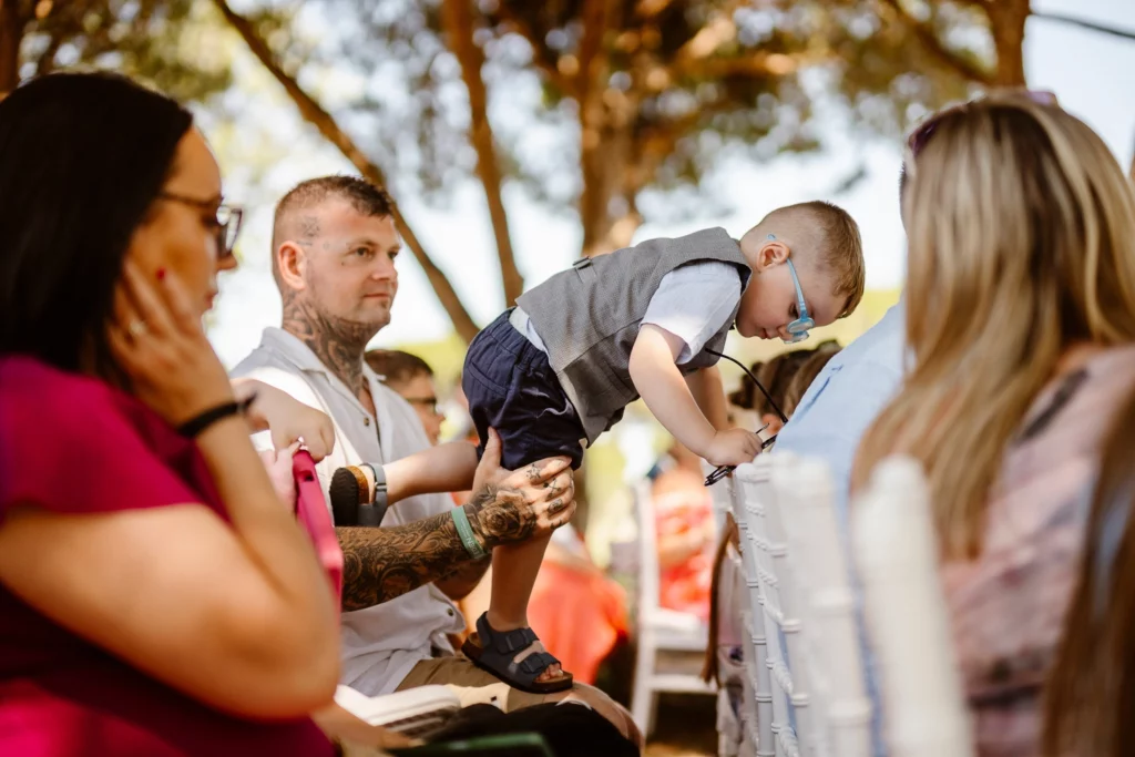 Candid moment of wedding guests and child at Portuguese outdoor ceremony