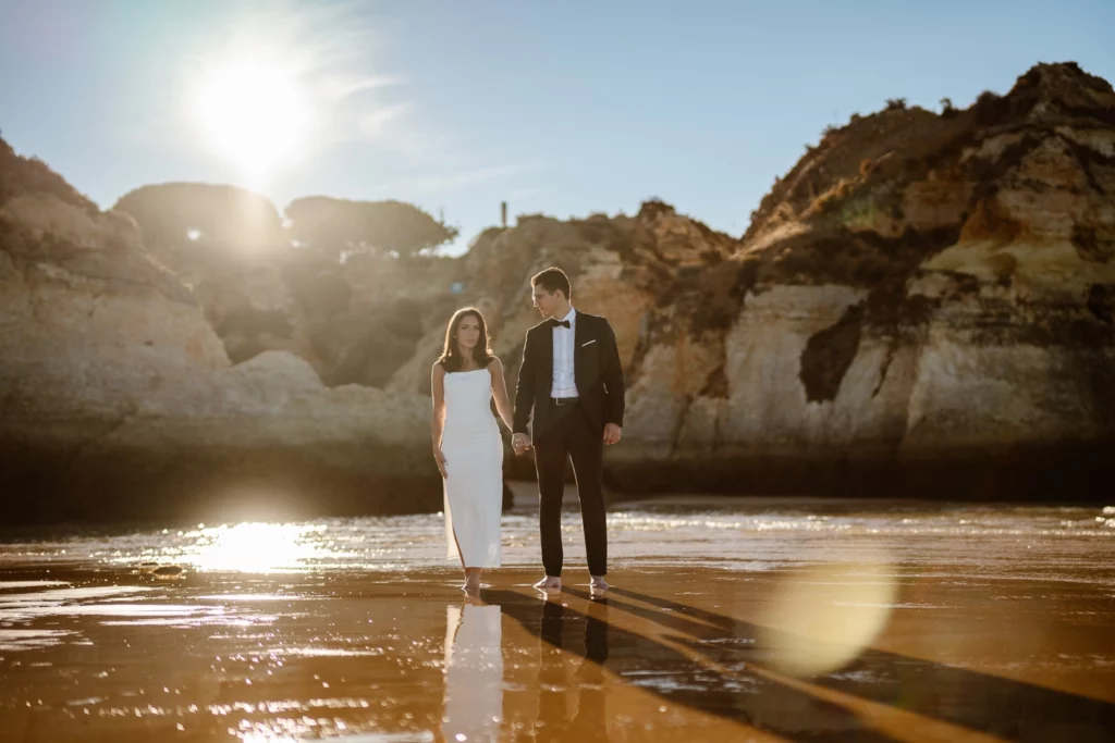 Wedding couple walking on wet sand during sunset elopement in Algarve
