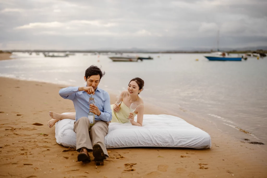 Romantic beach elopement in Portugal with bride and groom relaxing at shoreline
