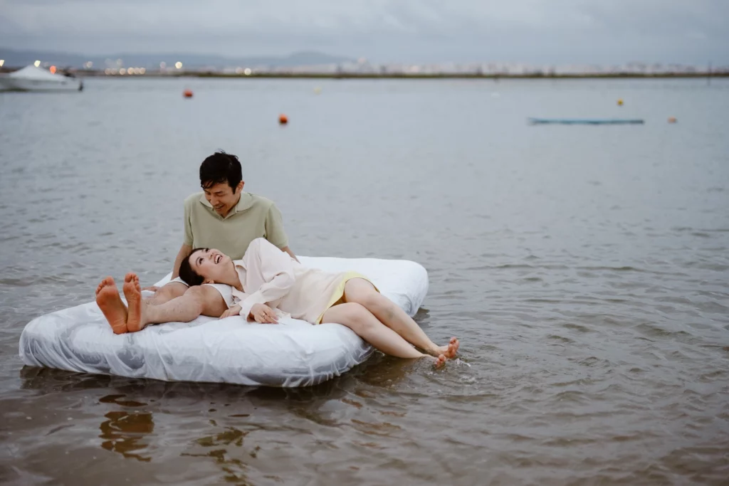 Intimate elopement photo session with couple on floating bed in the sea
