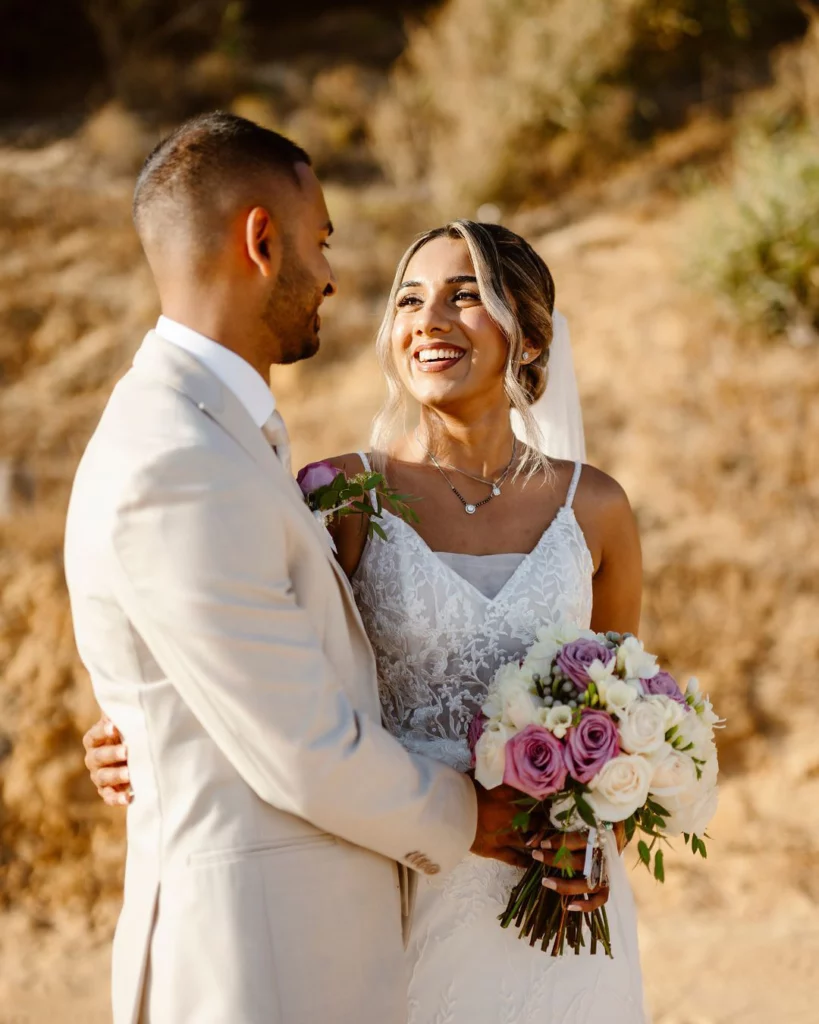 bride-and-groom-embracing-on-sandy-cliffs-algarve